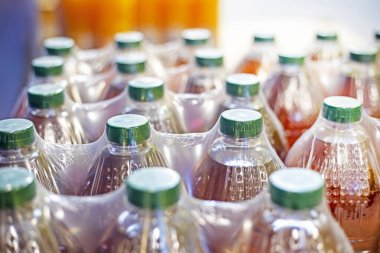 Meyve suyu ve diğer içecekler yeşil plastik kapaklı plastik kaplarda paketlenir.