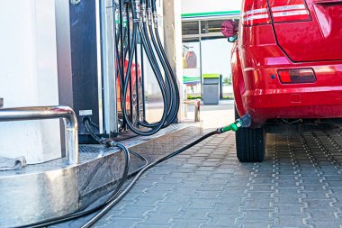 Evrensel bir benzin istasyonunda kırmızı bir arabayı LPG ile doldurmak. Ekonomik kriz. artan petrol ve akaryakıt fiyatları