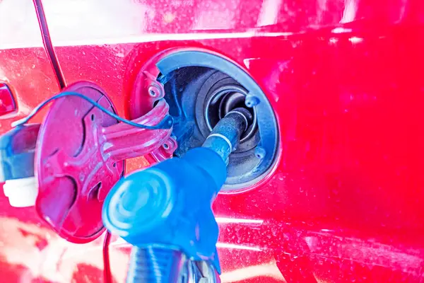 stock image close-up of a red car filling up with fuel. Global economic crisis and default