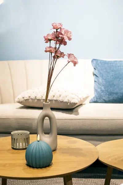 stock image vase with decorative flowers on a round table in the interior. Modern interior