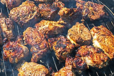 cooking meat on the grill on a barbecue on a sunny day, top view. Holiday Family weekends and rest clipart