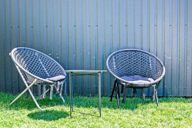 Dışarıdaki çimenlikte iki siyah kubbe sandalyesi. Sokaklar, kafeler ve bahçeler için mobilyalar. İlişkiler.