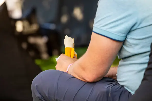 Stock image man eats street food outside. Street snack