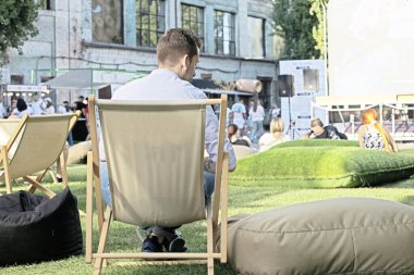 outdoor summer cinema with spectators on a sunny evening clipart