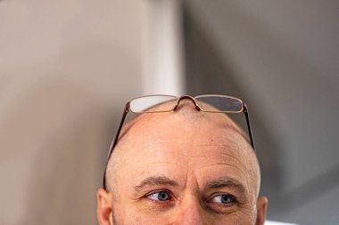 Alnında gözlük olan bir adam yukarı bakıyor. Fikir oluşturma