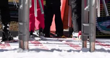 Kayakçı ailesi güneşli bir günde kayak pistinden aşağı inmek için asansöre biner. Kış tatili, Noel ve Yeni Yıl.