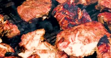 Lezzetli ızgara et parçalarını çevirip ızgara kapağını kapatıyorlar. Piknik. Tatiller