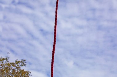 strong rope against the sky with clouds. Construction work at height clipart