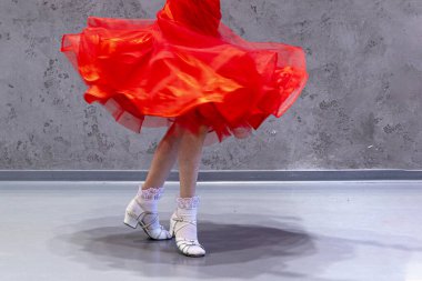 Kırmızı dans elbisesi ve dans ayakkabılarıyla dönen mutlu kız.