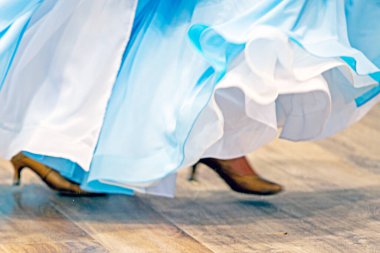 Açık mavi elbiseli kız turnuvada dans pistinde dans ediyor. Salon dansı.
