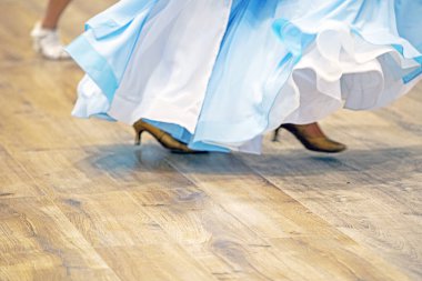 Açık mavi elbiseli kız turnuvada dans pistinde dans ediyor. Salon dansı.