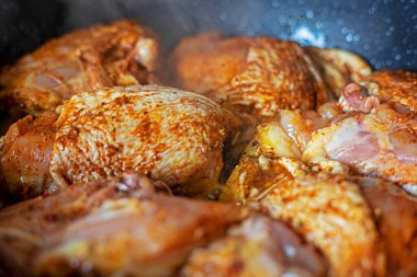 cooking delicious fried pieces of poultry meat with spices in a saucepan. Healthy eating and diet clipart