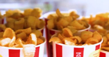 Kağıt bardakta farklı aromalı cips. Aile filmi izliyor.