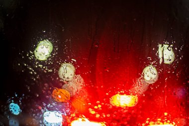 reflections of red brake lights from a car windshield in heavy rain and snow in a traffic jam. Road safety. Poor visibility clipart