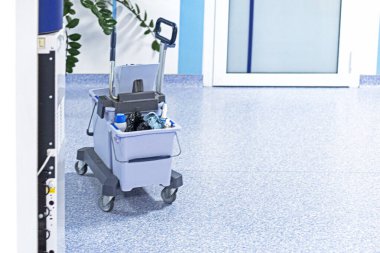 trolley with garbage in a light interior in a hospital clipart