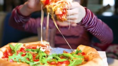 Kız bir kafede çift peynirli bir dilim vejetaryen pizza yiyor. yiyecek