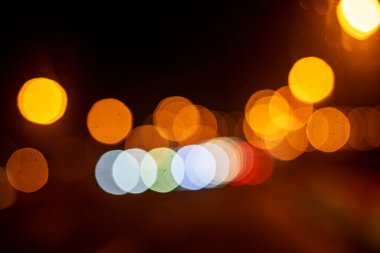 Aydınlatılmış bir otoyolda gece çok renkli ışıkların ve fenerlerin soyut arkaplanı