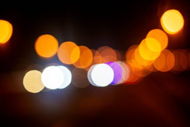 abstract background of multi-colored lights and lanterns at night on a lighted highway clipart