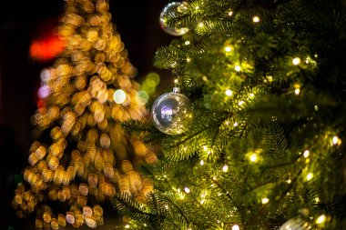 Yeni yıl ağacı, camında süs topları ve çelenk var. Noel ve Yeni Yıl