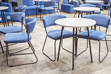 Yuvarlak masalı ve mavi sandalyeli kafe.