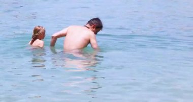 Mutlu kız babasından boğulması için onu denize atmasını ister. Aile tatili, okul tatili