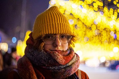 teenage girl in a hat on the background of a Christmas city clipart