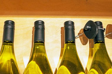 Süpermarketteki vitrinde şeffaf cam bir şişede beyaz köpüklü şarap ya da porto şarabı. Beyaz şarap tatma