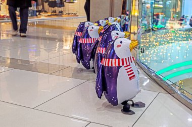 funny inflatable toy penguins in scarves in the interior of the supermarket. Preparation for Christmas clipart