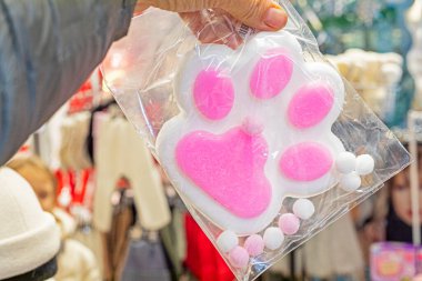 holding a cute pink paw antistress trail. Modernity and fashion clipart