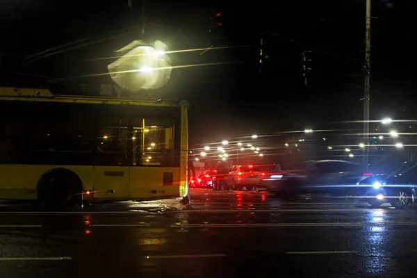 Kavşaktaki trafik sıkışıklığı ve gece geç saatlerde yağmurda bozuk bir tramvay. Yolda ve güvenlikte görüş mesafesi düşük.