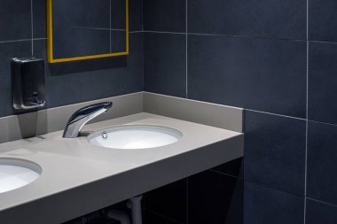 Banyoda koyu fayanslar olan şık bir iç mekan.