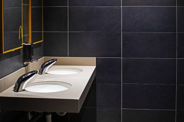 Tuvalette ve banyoda koyu fayanslar olan şık bir iç mekan.