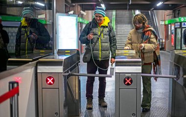 Mutlu genç kız ve baba metrodaki turnikelerden geçiyor. Günlük hayat.