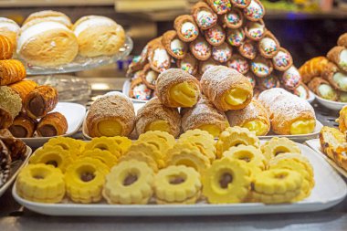 Tüpler ve kurabiyeler kremalı ve çikolatalı, karamel ve reçelli vitrinde. İtalyan tatlısı, Avrupa seyahati