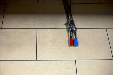 Yerde sıcak ve soğuk su düğmesi var.