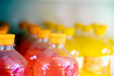 Şeffaf tetra paketlerinde portakal ve pembe meyve suyu içer.