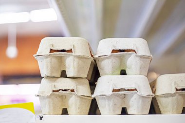 Süpermarkette tezgahın üzerinde karton bir kutuda tavuk yumurtası. Paskalya hazırlığı