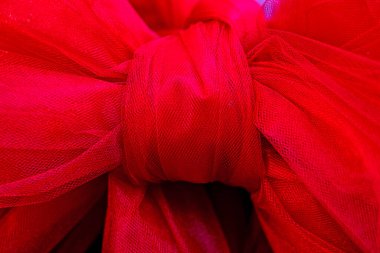 Şeffaf malzemeden yapılmış kırmızı fiyonklu arka plan. Sevgililer Günü, tatil