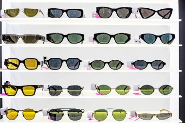 Güneş gözlükleri farklı şekillerde ve tasarımlar süpermarkette sergileniyor. Gözlerimi güneşten ve kırışıklıklardan koruyorum