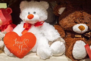 Yumuşak oyuncak ayıların pençelerinde kırmızı bir kalp ve yazıtta seni seviyorum.