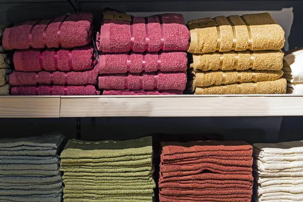 bej, kırmızı, yeşil havlular katlanmış raflarda.