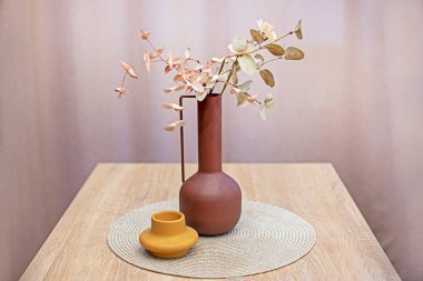 Yılın rengi, pastel bir vazonun içindeki kuru ikebana.