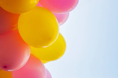 Mavi gökyüzünün arka planına karşı çok renkli şişme balonlar. Tatil