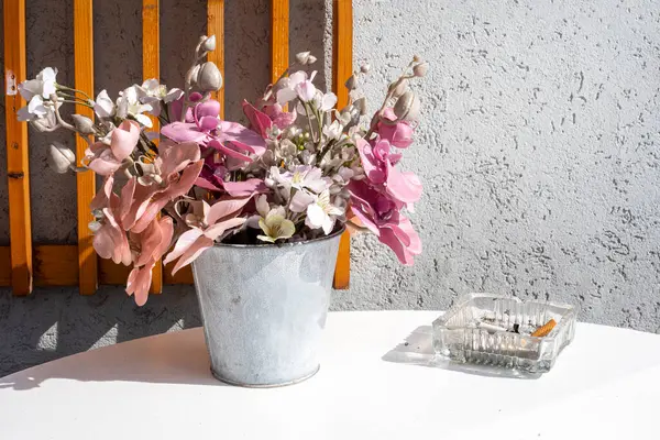 Güneşli bir günde kovadaki güzel çiçekler Kafedeki bir masada