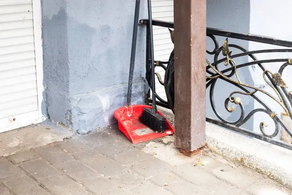 Süpermarketin yanında elinde süpürge olan faraş. Sokakları temizliyorum.