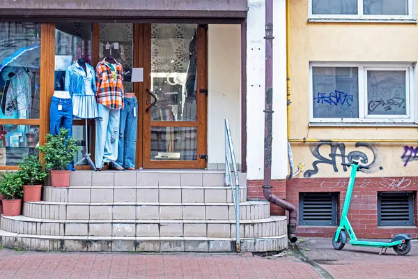 Erkek kıyafetleri mankenlerin üzerinde şık bir erkek butiğinin yanında.