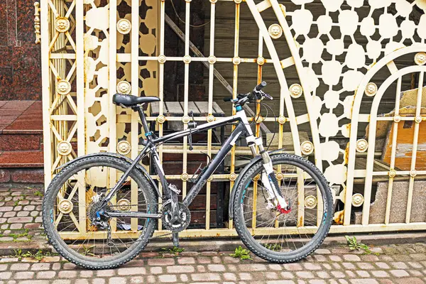 Demirden bir çitin yanında park edilmiş bisiklet.