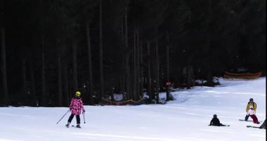  Kayakçı Alplerdeki kırmızı pistten yavaşça iniyor.