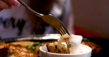 Patatesli krepi çatalla ekşi kremaya batırmak. Ulusal Mutfak