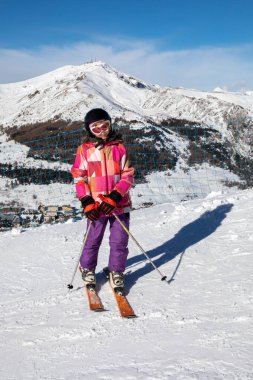 Alplerdeki İtalyan kayak merkezine inmeden önce yamaçta genç bir kayakçı. Tatil